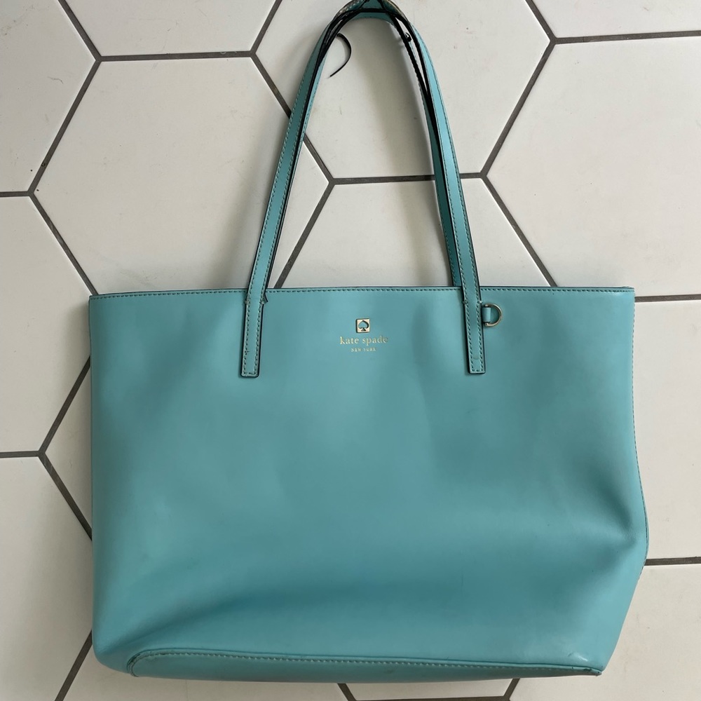Beautiful blue Kate Spade purse showing wear on straps